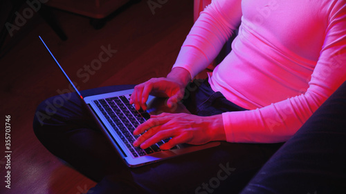 Macro shooting, men's fingers, which print on a laptop, evening muted bluered light photo