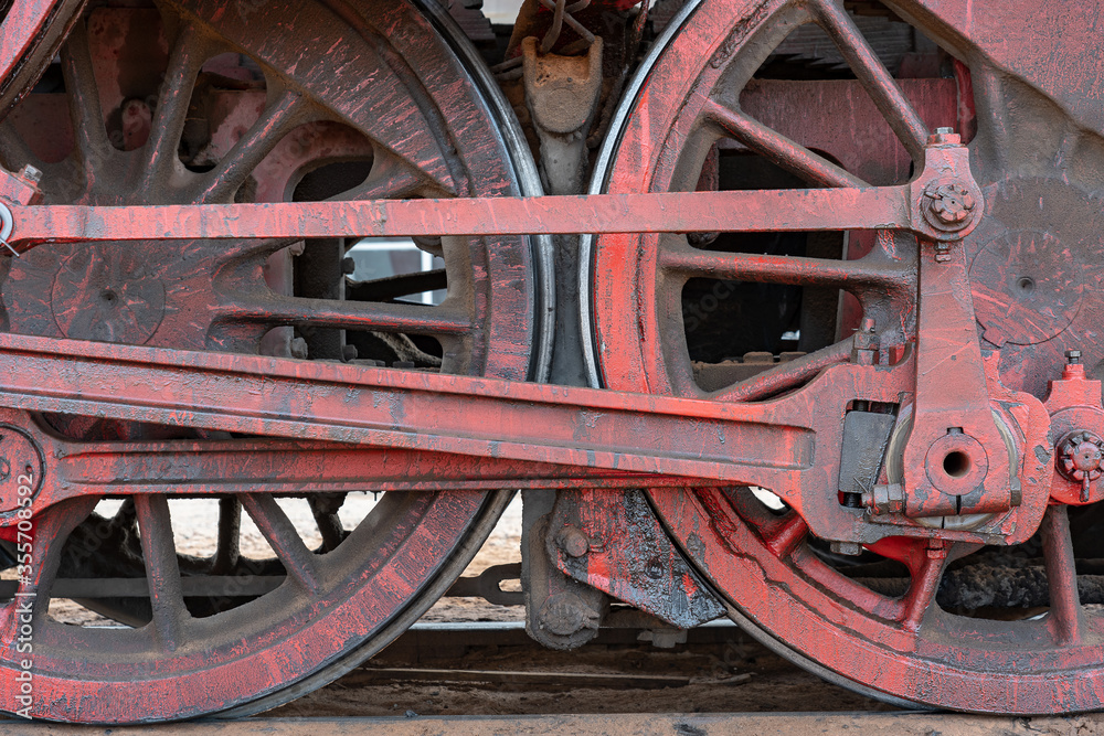 Close up shot of the red steel wheels of an old steam train