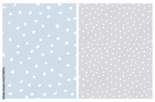 Cute Hand Drawn Abstract Irregular Polka Dots Vector Pattern Set. White Brush Dots on a Pastel Blue and Light Gray Background. Bright Infantile Style Vector Print. Simple Dotted Layout.