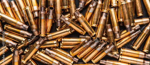 Empty cartridge cases for a carbine or rifle. Background of shiny brass cartridges for cartridges to illustrate armed conflict, war or shooting events.