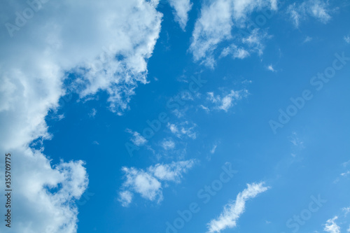 White clouds on a back of blue sky. Clear sky with fluffy light clouds.