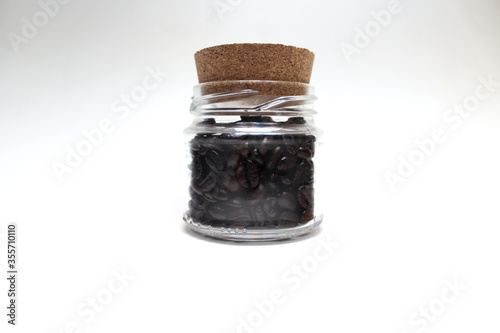 Coffee in the pot.Image showing a composition of roasted coffee beans in a jar with a stopper style lid.