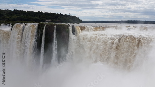 photograph of the famous  grandiose and mighty Iguazu Falls  which give off magical water vapor  seen from the Brazilian side