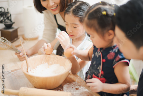 Young Asian love family are preparing the dough powder, cookies, cake on table in the kitchen which Excited smiling and felling happy. parent and daughter are cooking on the day at home.