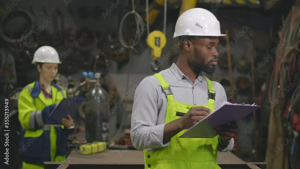 Diverse inspectors supervising equipment of factory workshop Diverse inspectors supervising equipment of factory workshop
