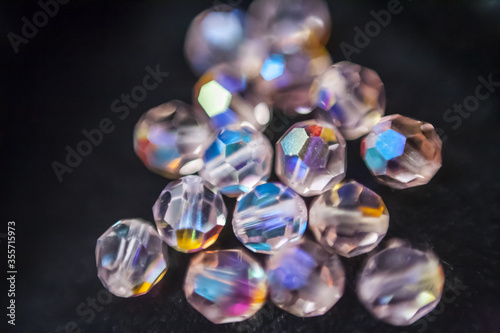 Beautiful opalescent glass beads closeup on black soft velvet background, abstract blur background