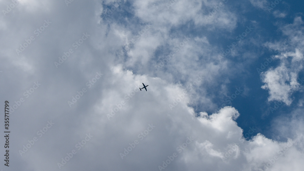 Aeroplane flying over the clouds of a blue sky