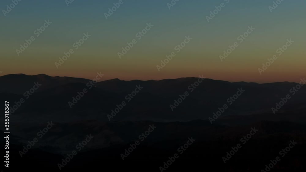 360 degree pan over a rugged mountain range at sunrise or sunset as the fiery orb of the sun rises over the horizon in a colorful orange sky 360 degree pan over a rugged mountain range at sunrise or sunset as the fiery orb of the sun rises over the horizon in a colorful orange sky