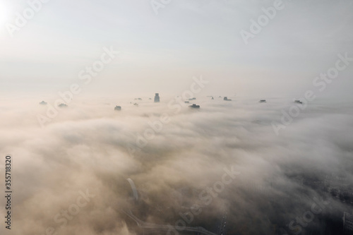 Aerial view of the city in the fog. Skyscrapers above the fog