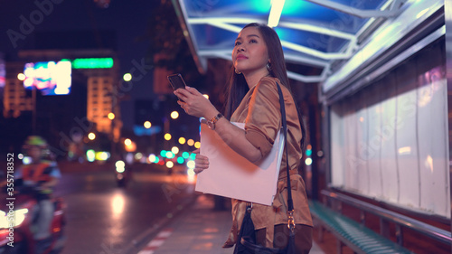 Young asian business woman calling taxi on city street photo