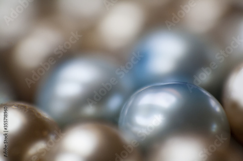 Beautiful opalescent glass beads closeup on black soft velvet background, abstract blur background