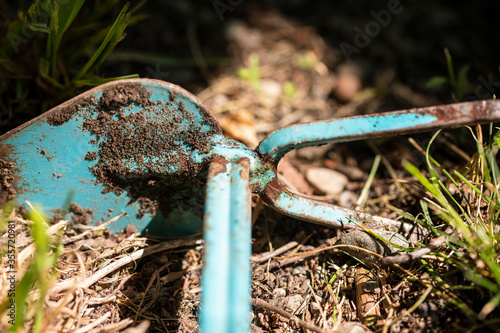 Gartenarbeit, mit blauer Gartenhacke.