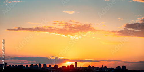 Beautiful sunset sky with clouds over city skyline background. Kyiv city. Ukraine.