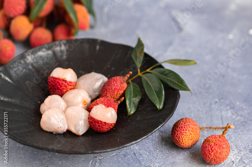 Lychee with leaves on gray background. Tropical fruit. photo