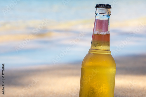 Cool refreshing alcoholic drink in the sand & shade at a tropical beach next to the ocean.  Concept for retirement, travel and stress free.