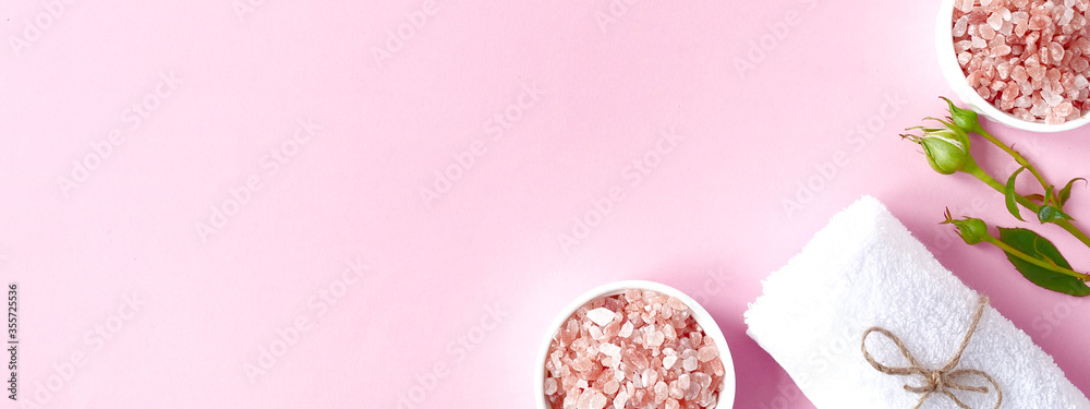 Spa flatlay composition. Sea salt in jar, towel, flower on pink background. Top view, copyspace, banner. Daily care concept, relax and rest, bath procedure Spa flatlay composition. Sea salt in jar, towel, flower on pink background. Top view, copyspace, banner. Daily care concept, relax and rest, bath procedure