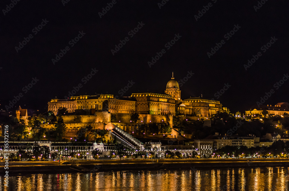 Illuminated famous Buda castle by night across river Danube in Budapest Hungary