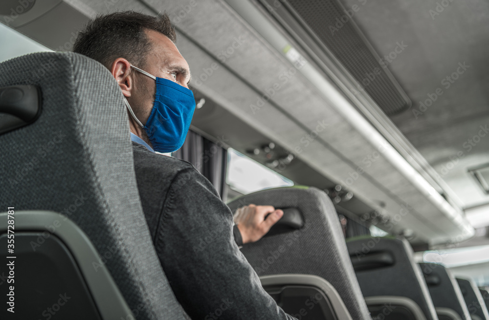 Men in Safety Breathing Mask on His Face Traveling Alone in a Bus Coach - obrazy, fototapety, plakaty 
