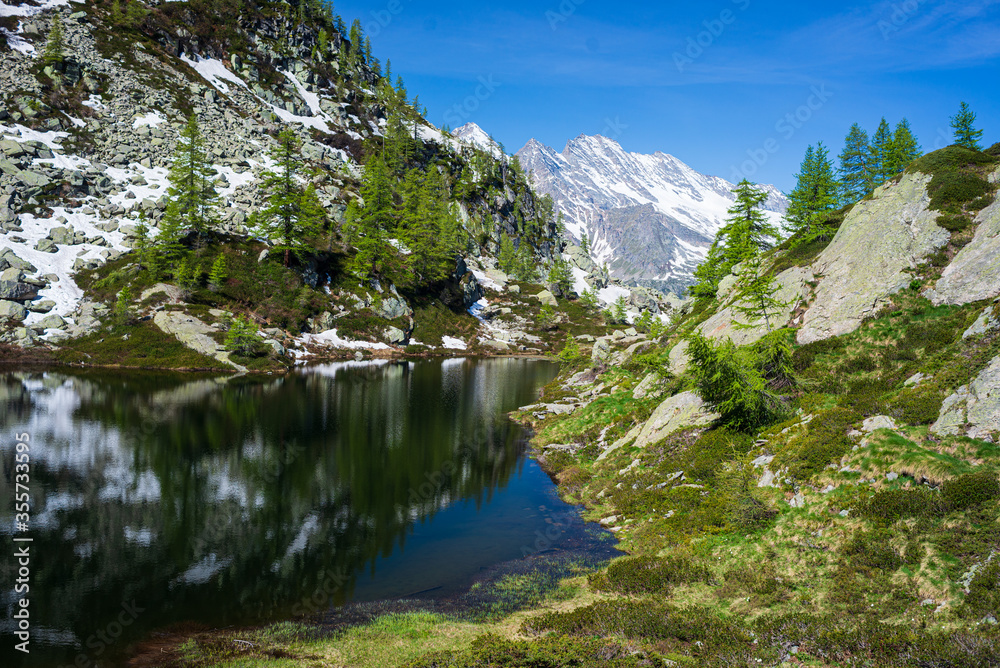 Alpine lake in idyllic environment amid rocks and forest. Natural reservoir of fresh water at high altitude on the mountains. Alpine lake in idyllic environment amid rocks and forest. Natural reservoir of fresh water at high altitude on the mountains.