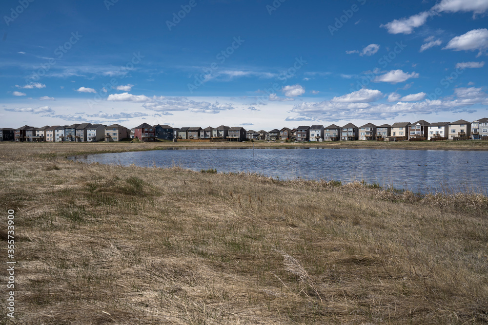 Calgary, Alberta, Canada, June 01 2020:  An subdivision developed up to designated habitat at the City Scape Wetlands.