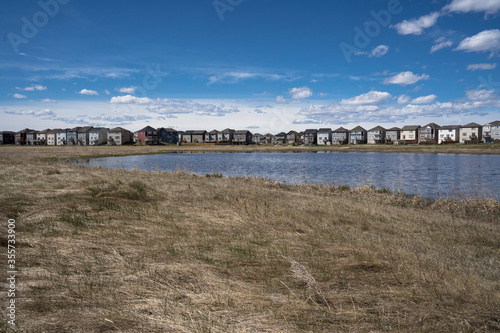 Calgary, Alberta, Canada, June 01 2020:  An subdivision developed up to designated habitat at the City Scape Wetlands. © Ramon Cliff