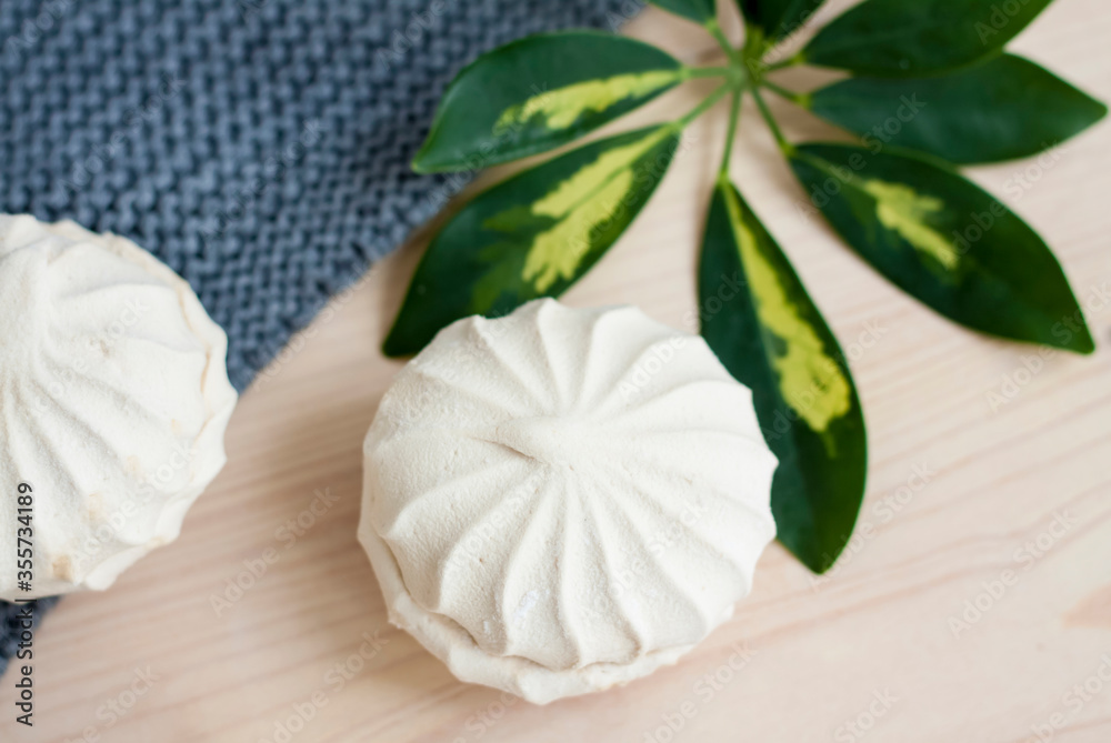 Marshmallows. Vanilla sweet homemade marshmallows. Light composition with green natural leaf and plaid. Violet flower. Sweet delicious dessert. Marshmallows. Vanilla sweet homemade marshmallows. Light composition with green natural leaf and plaid. Violet flower. Sweet delicious dessert.