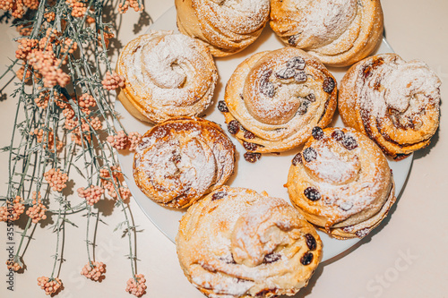 some easter cruffin with raisin, powdered sugar and deco flowers photo