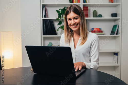 Cheerful beautiful caucasian girl student professional standing at home in office looking at camera, happy confident entrepreneur  laughing face posing alone, head shot close up view portrait. Webcam
