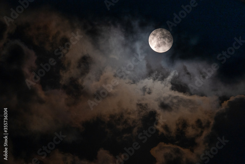 Full Moon peaking through beautiful cloudscape