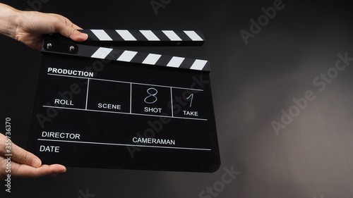 Vászonkép A Hand is holding Black clapper board or movie slate use in video production, movie, film, cinema industry on black background