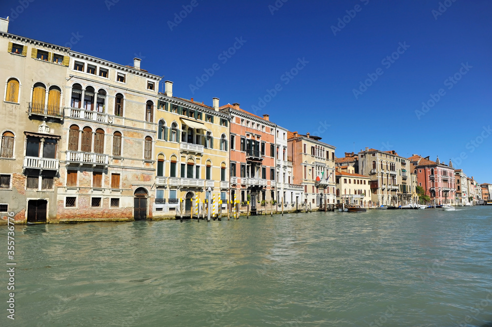 Venice channels with boats, gondolas, and colorful houses and towers