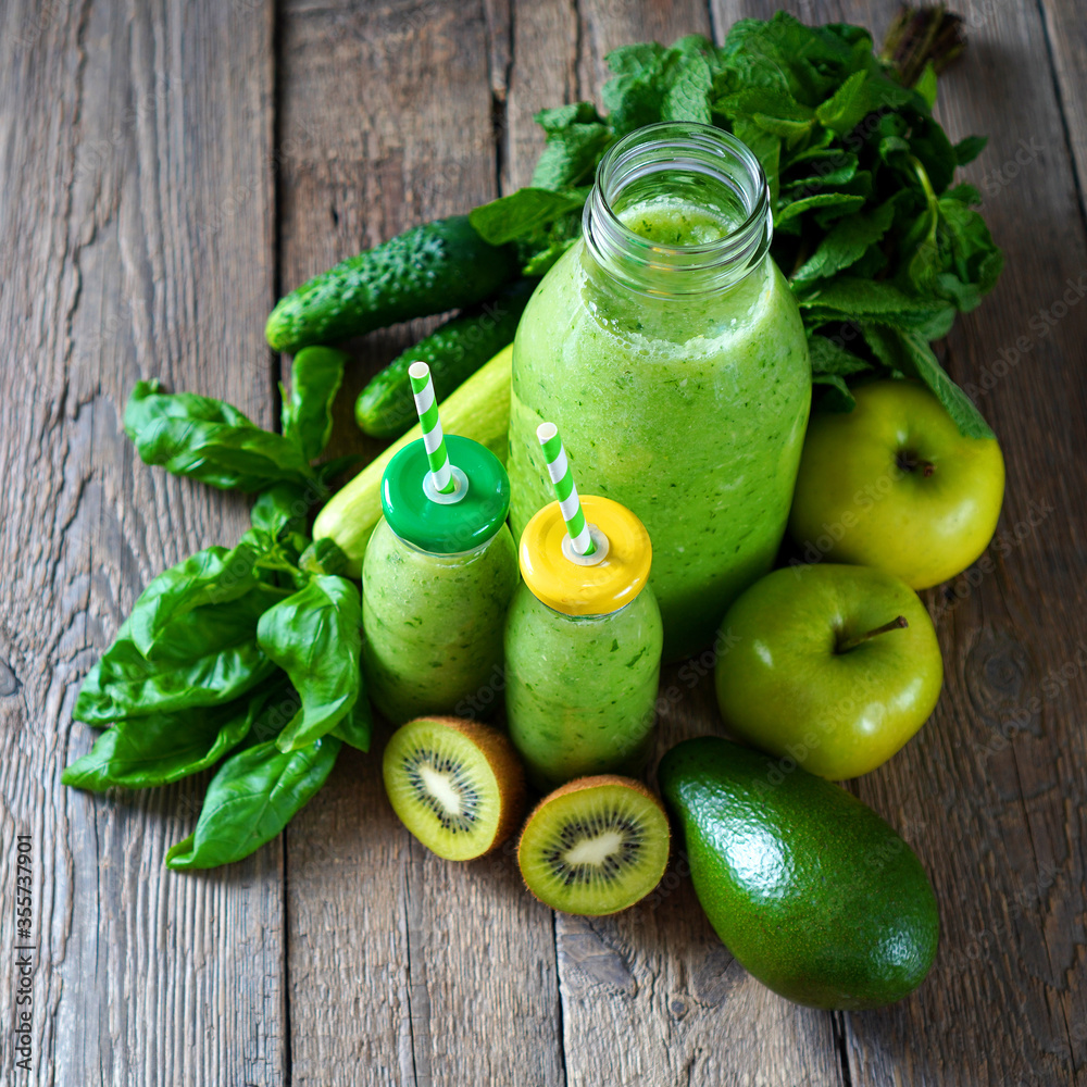 Detox juice. Summer green smoothie on the rustic wooden table. Drink made with green fruits, vegetables and greenery. Square photo. Detox juice. Summer green smoothie on the rustic wooden table. Drink made with green fruits, vegetables and greenery. Square photo.