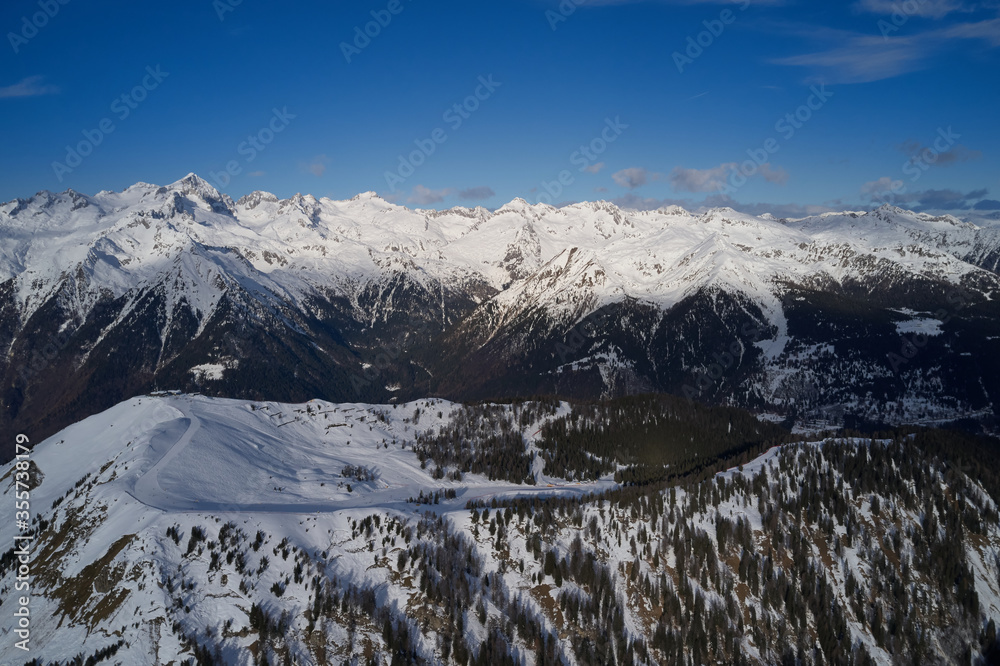 Panoramic aerial view of  Brenta Dolomites, snow on the slopes of the Alps  Madonna di Campiglio, Pinzolo, Italy. The most popular, ski resorts in Italy. Aerial photography with drone. Ski slopes