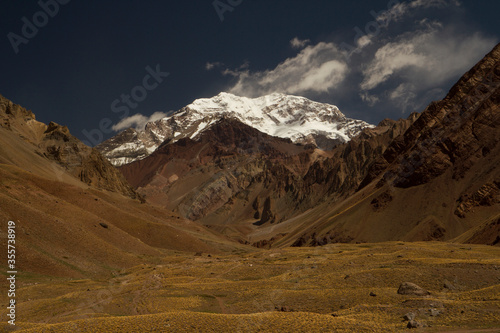 Aconcagua mountain snowy peak and golden valley meadow. Panorama view of Mount Aconcagua in Mendoza, Patagonia Argentina. Aconcagua is one of the world's seven summits