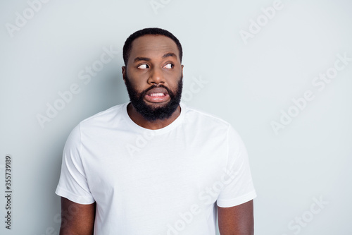 Photo of terrified dark skin african young guy look white people hate dislike afraid walk street outdoors want stop bully unhappy citizen person wear t-shirt isolated grey color background