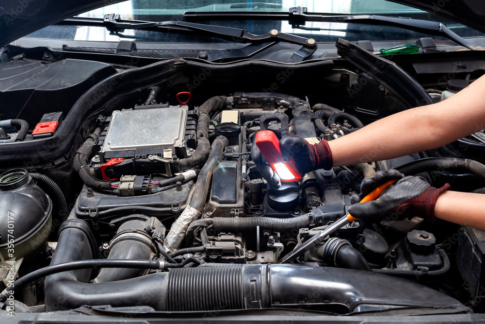 mechanic looking for a fault on a compressor engine using a flashlight mechanic looking for a fault on a compressor engine using a flashlight