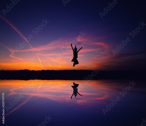 A silhouette of a woman jumping for joy