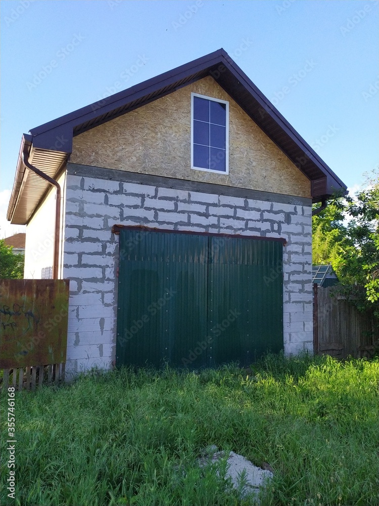 An unfinished small country house with a garage An unfinished small country house with a garage