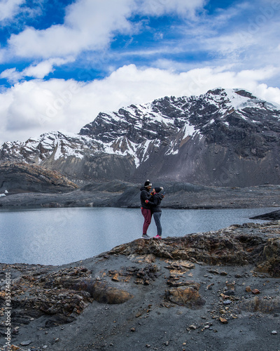 Fotografi couple in a glacier, near a river and snowy