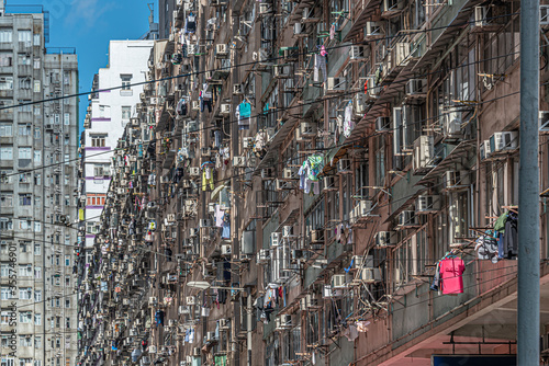 Building residential with clothing hanging from the windows on a sunny day at Hong kong