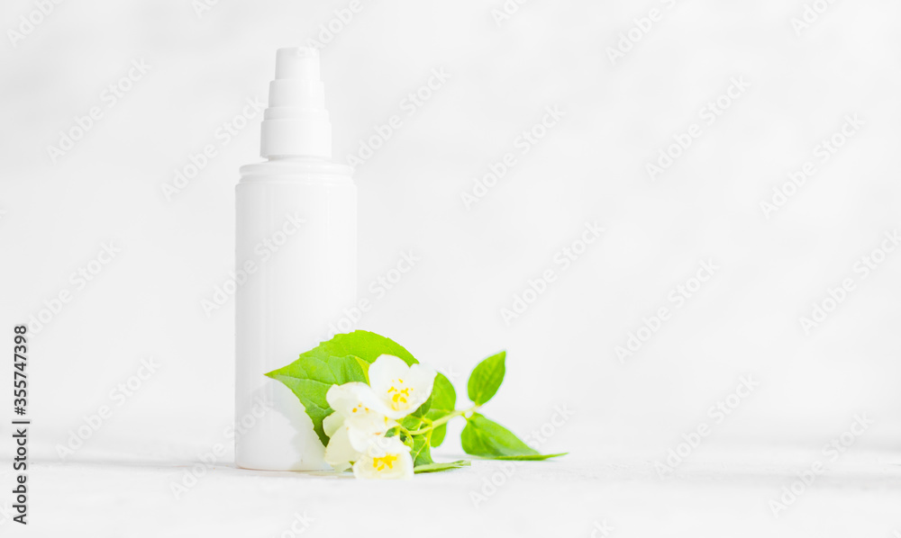 Unbranded skincare products plastic bottle with dispenser and flacons. Tube for cream shampoo. Green jasmine flowers and their shadows on the white background isolated. Mockup and copy space - obrazy, fototapety, plakaty 