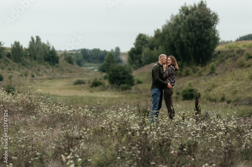 Man embracing and kissing her woman in nature. Happy couple © Maksym