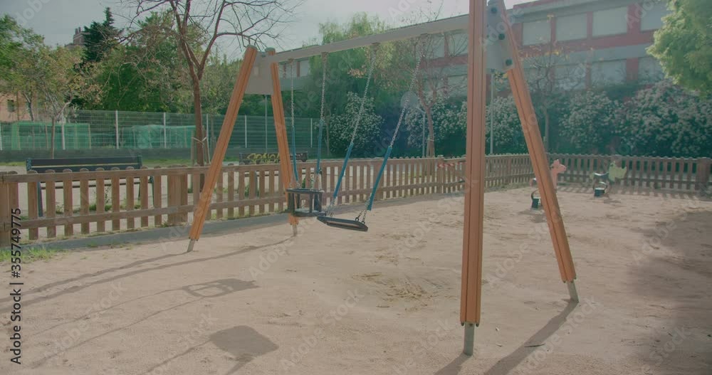 Swing closed with warning tape in children's playground in public park of coronavirus covid-19 pandemic quarantine and social isolation Swing closed with warning tape in children's playground in public park of coronavirus covid-19 pandemic quarantine and social isolation