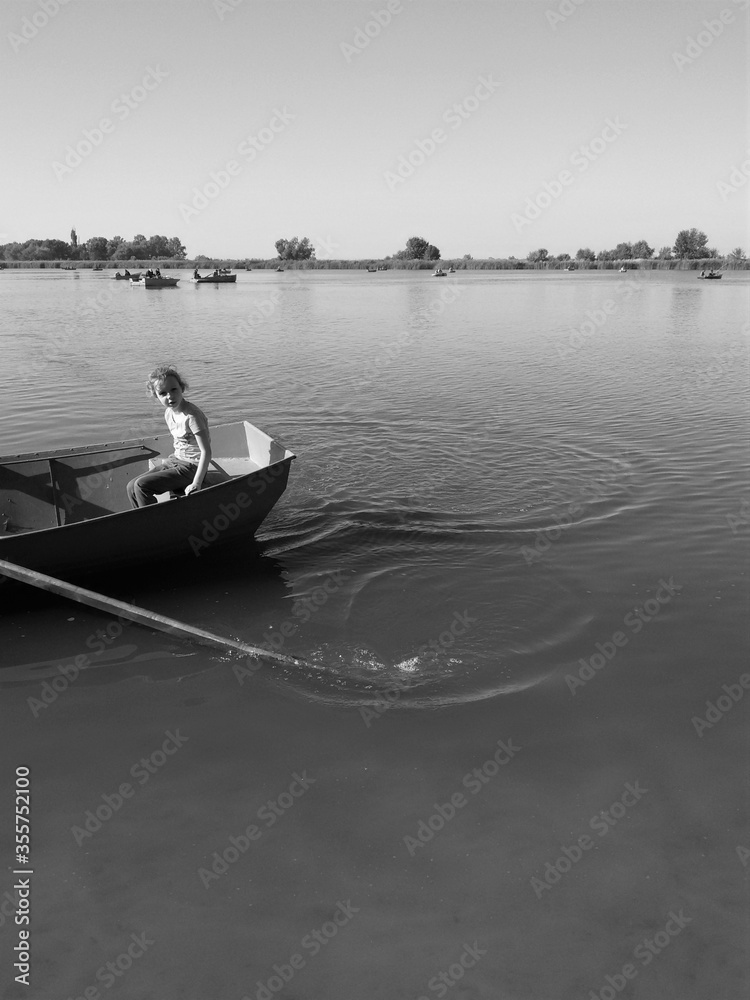 A child in a wooden rowing boat on the water