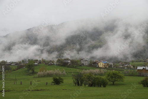 Village thailand with foggy landscape mountains misty forest with tree and house in the moring winter nature / View of foggy house on hill countryside