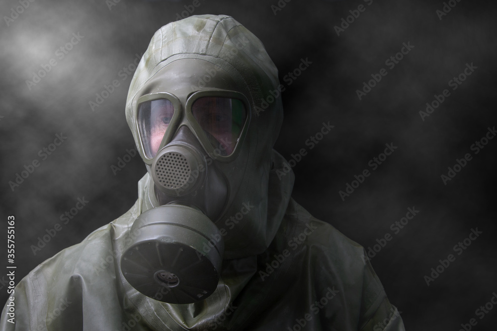 Man in NBC full protective suit and gas mask. Dark future. Will these protective suits soon be essential for survival against the corona virus?. Man in NBC full protective suit and gas mask. Dark future. Will these protective suits soon be essential for survival against the corona virus?.