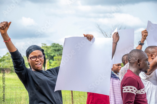 group of protesting young black african people holding signs with free copy space photo