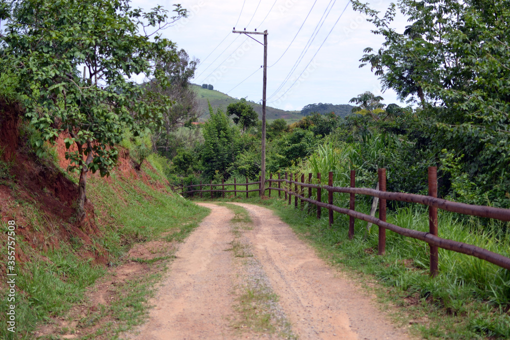 unpaved road with a rustic fence