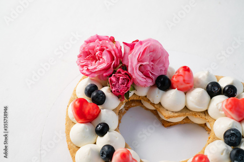 Homemade heart shaped cake on white table. Food delivery. Homemade baking. Close-up..