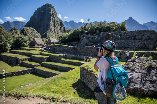 Blonde woman taking pictures of machu picchu